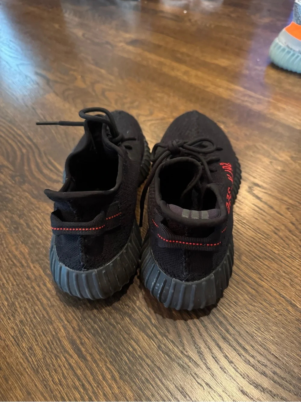 Black Yeezy 350 sneakers with red text